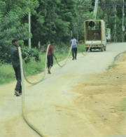 Men Walking a Hose Down the Street